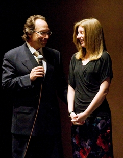 On stage at ASU’s Gammage auditorium, engineering honors student Jessica Piper (right) accepts congratulations for winning the ASU Origins Project Science and Culture Essay Competition from ASU Origins Project director Lawrence Krauss. Photo: Tom Story/ASU 