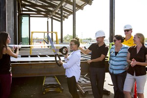 Alia Taqi, team ASUNM's communications manager, leads a ribbon cutting ceremony held at the team's construction site, Accelerated Construction Technologies, in August.