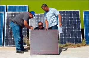 An instructor explains details of a solar panel to students. 