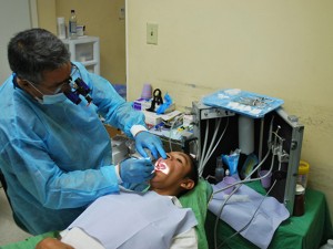 Dr. Tony Gonzalez, a volunteer dentist with IMAHelps, treats a patient on the August 2015 mission to El Salvador. Engineering Smiles' mobile dental clinic is anticipated to expand IMAHelps' outreach efforts by at least 100 patients per mission, as well as providing them with a stable and functional work environment. Photograher: Marilyn Chung/ Desert Sun Newspaper