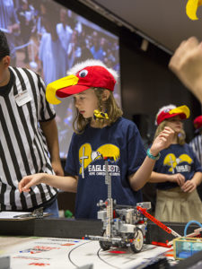 Donned in colorful eagle hats, members of the Eaglebots team, from Hope Christian Academy in Chandler, Arizona, prep their robot's first run at the FIRST® LEGO League state championship tournament on January 15, 2017. 