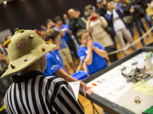 A volunteer judge wearing a safari hat decked out with LEGO bricks and a striped referee shirt watches as teams compete at the FIRST® LEGO League state championship tournament on January 14. Nearly 80 ASU student and staff volunteers helped with the recent championship tournament which was held throughout January 14-15, 2017. 