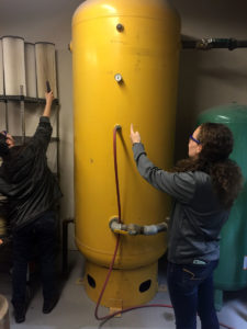 Mechanical engineering undergraduate students Celine Chang and Kaitlin Kreck assess gauge pressure and a name plate at a manufacturing site.
