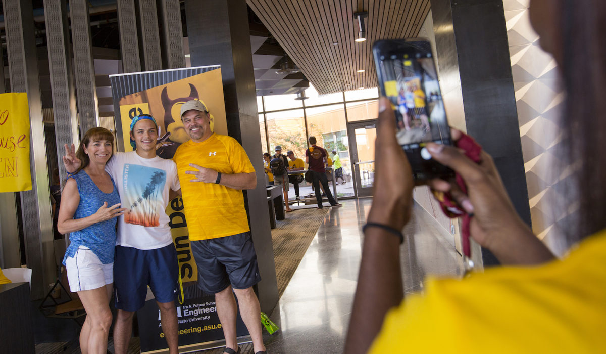 Photo of three people having their picture taken on a smartphone: caption - Welcome home Sun Devils! Parents and their students moved-in to Tooker House on Aug. 12-13.