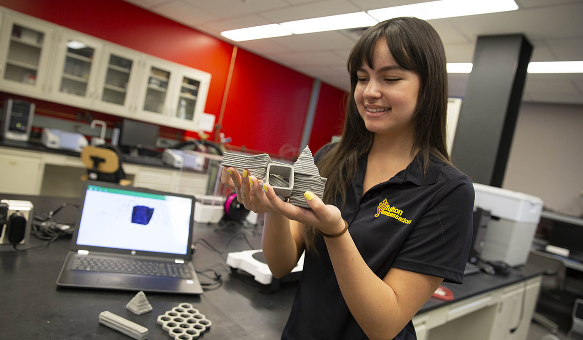photo of girl holding items. Caption: Civil engineering student Emily Alcazar worked to advance the current state of 3D-printed concrete in Professor Narayanan Neithalath’s lab for a future of faster, cheaper and cleaner construction. Photographer: Jessica Hochreiter/ASU