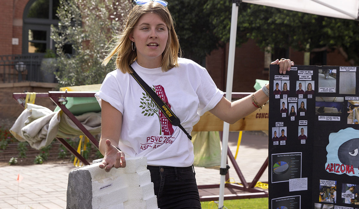 Photo of a woman next to a poster. Caption: ASU concrete canoe team project manager Natalie Miller described the materials her team used to make its canoe, “Bullet Bill,” during a public displays of students’ concrete canoes and steel bridge prototypes on campus before the start of the ASCE Pacific Southwest Conference competitions. Photographer: Erika Gronek/ASU