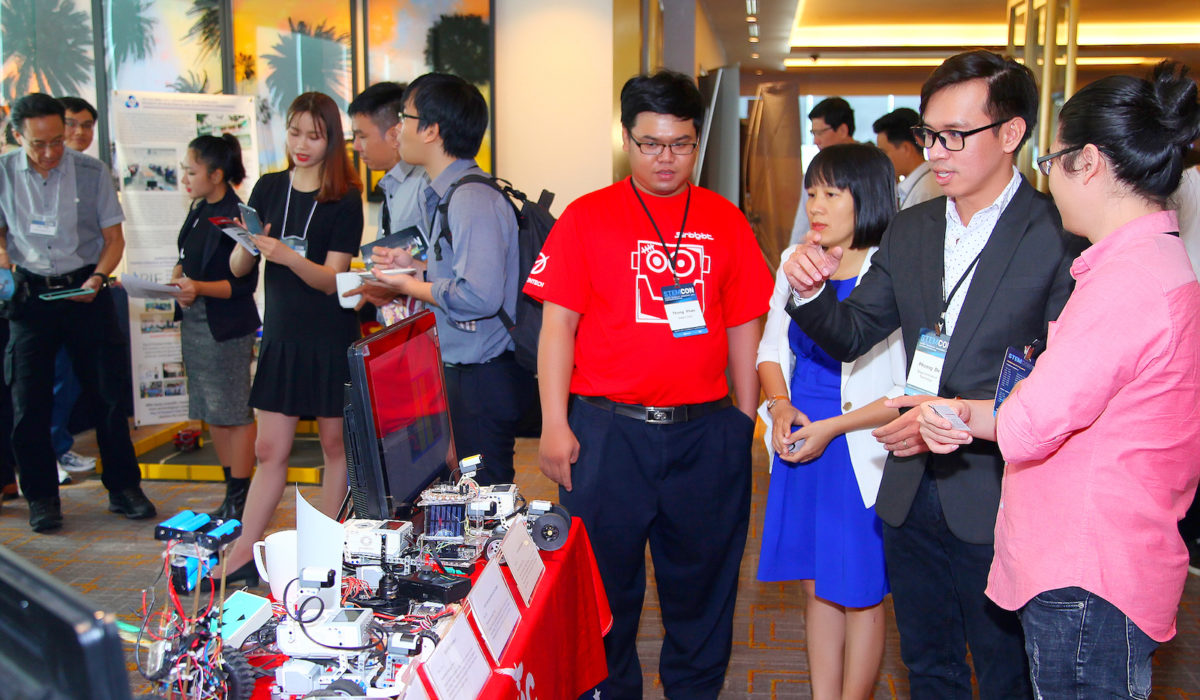 Participants visit student-created robots at the Saigon Tech booth in the STEM Innovation Showcase Exhibition at STEMCON.