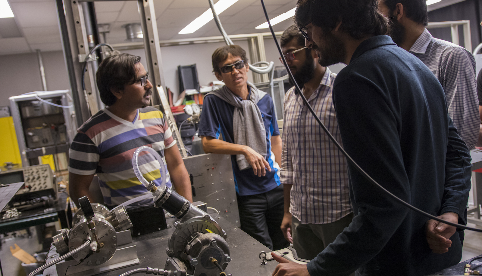 Five men standing inside a lab