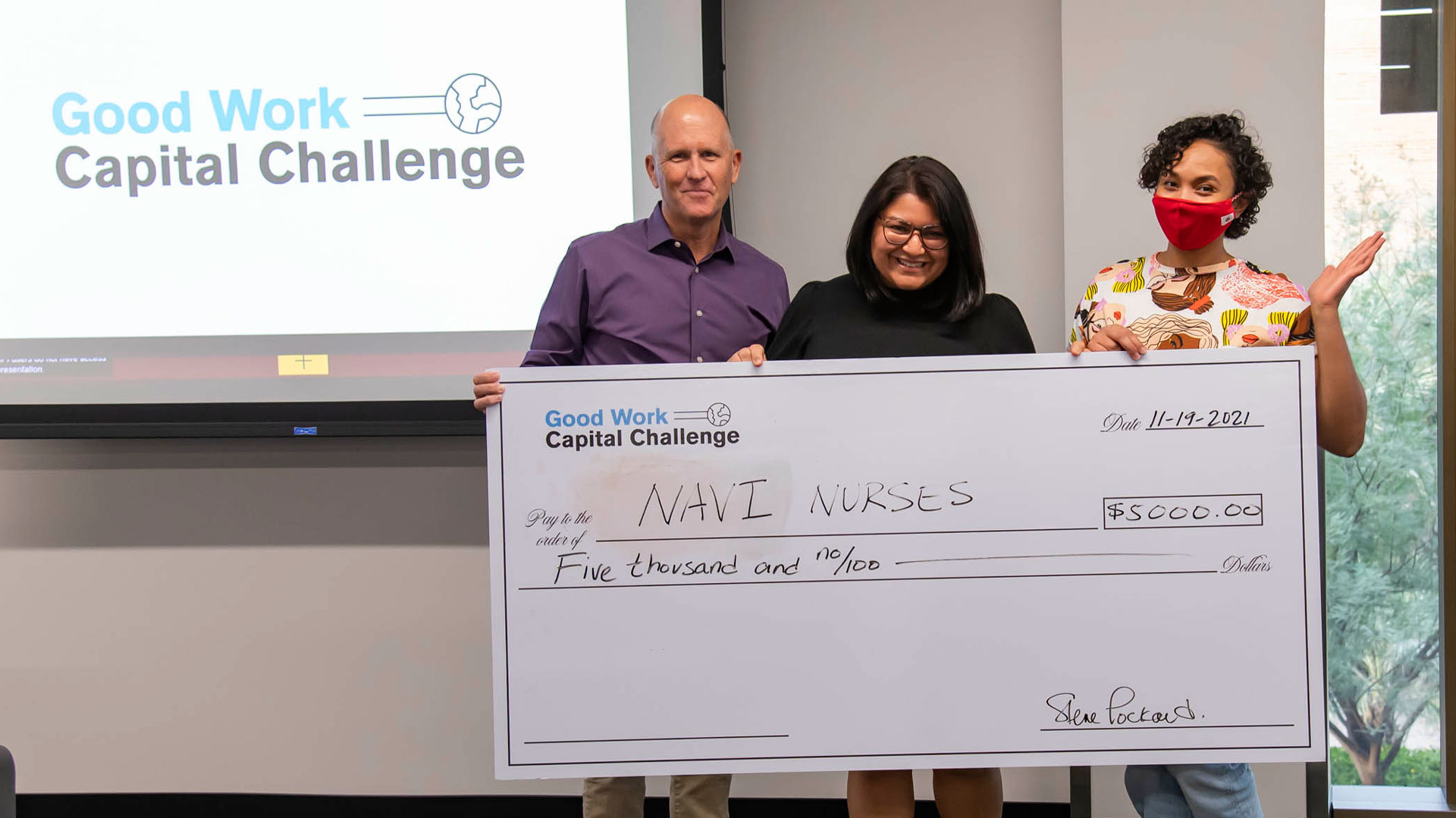 Steve Lockhard presents a $5,000 check to Jasmine Bhatti and her business partner Ayan Said from the Good Work Capital Challenge.