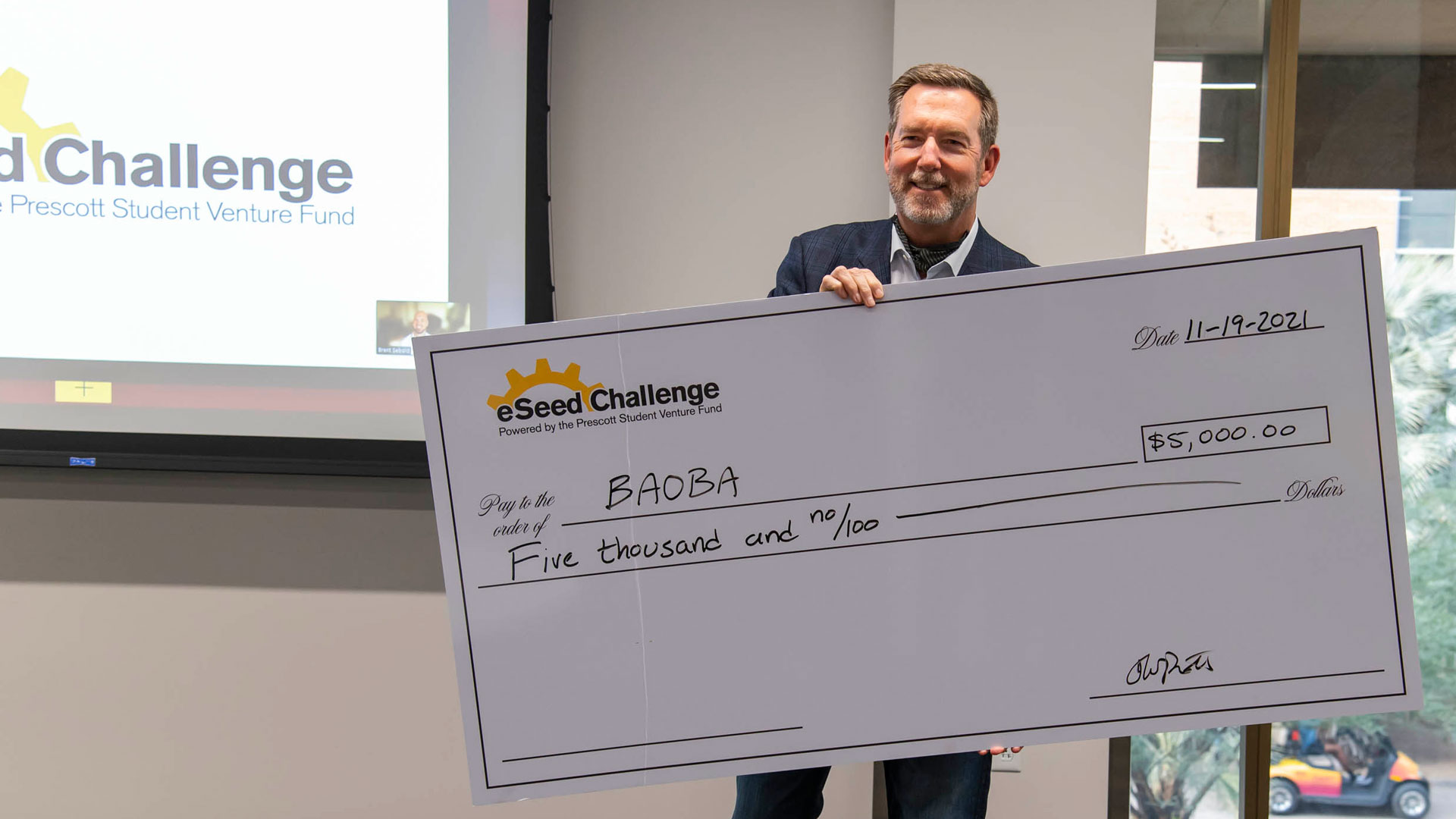 Tom Prescott presents a check for $5,000 for Prudence Zhu’s Baoba Lending startup.