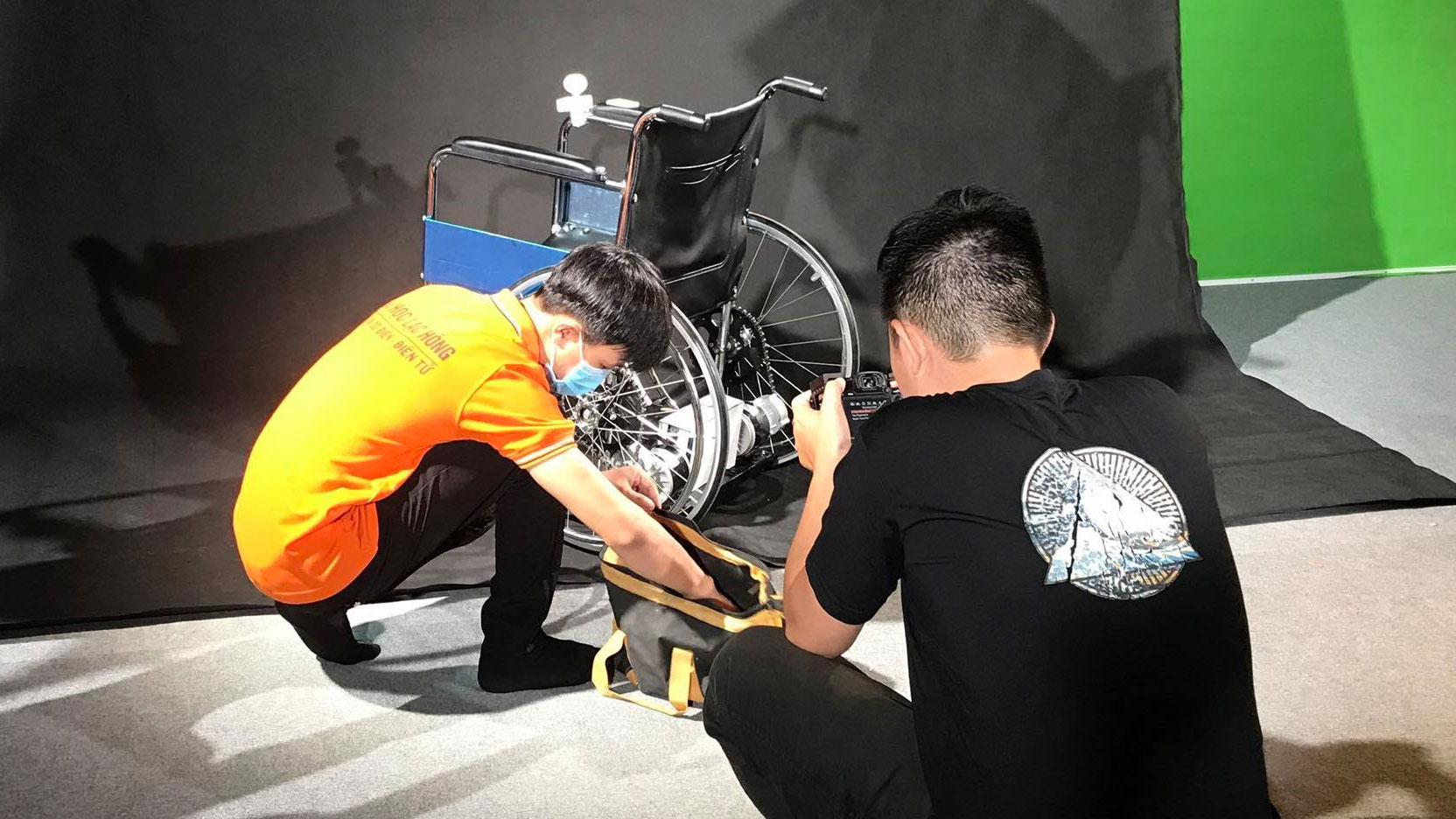 Two students from Lac Hong University in Vietnam work on a wheelchair device for Engineering Projects in Community Service.