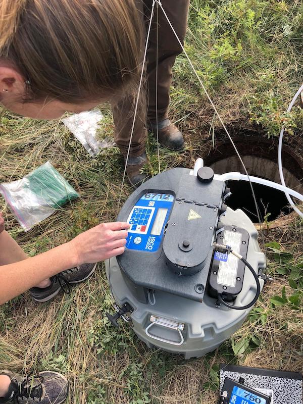 Erin Driver adjusting settings on a wastewater sampling device