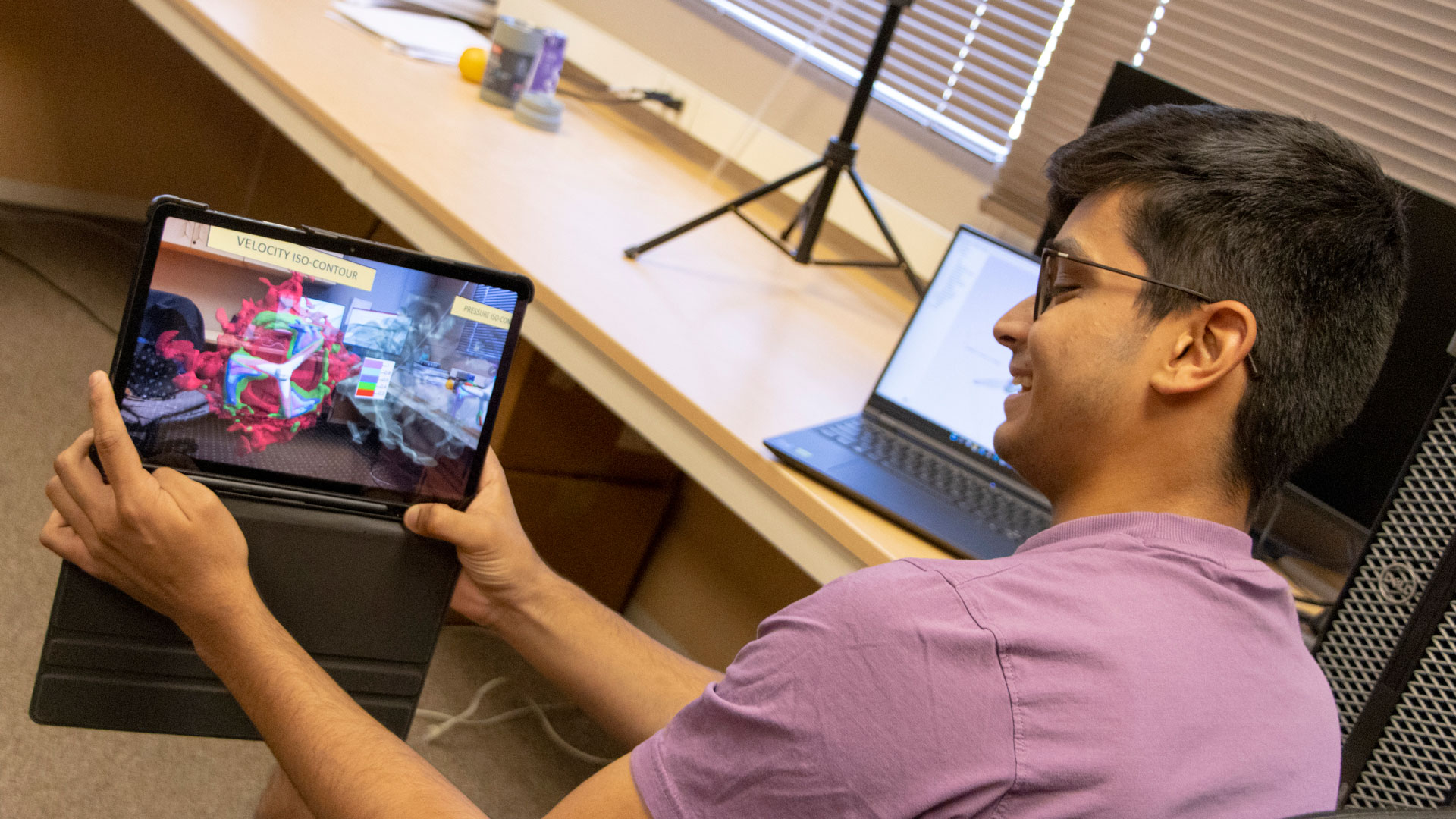 ASU aerospace engineering undergraduate student Parin Trivedi holds a tablet with augmented reality images for exploring vortex and flow data.