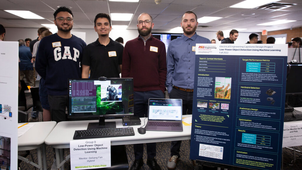 Four students pose at their capstone project display. 