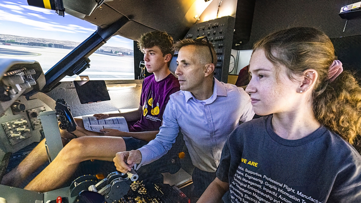Second-year aeronautical management technology (professional flight) student Billy Kitchen (left), faculty member Greg Files and recent graduate Taylor Hayslett (right) go through pre-flight checks in the CRJ 200 cockpit simulator on ASU’s Polytechnic campus