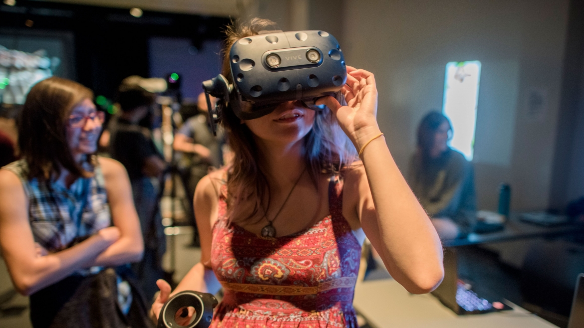 A woman uses a VR headset at the School of Arts, Media and Engineering’s Digital Culture Showcase in 2019.