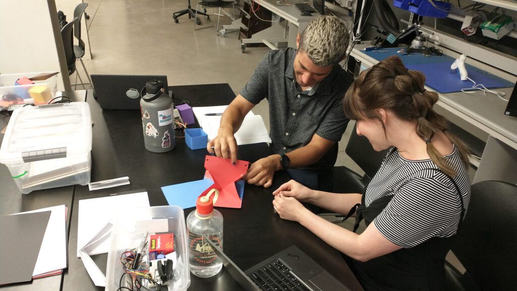 The Foldable Robotics Day Camp teaching team explored the motion of and created a six degrees of freedom origami device as a prop to teach students with.