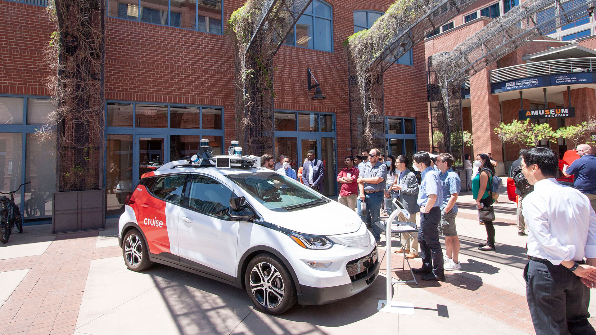 A crowd gathers near an electric autonomous vehicle on the ASU campus at an event