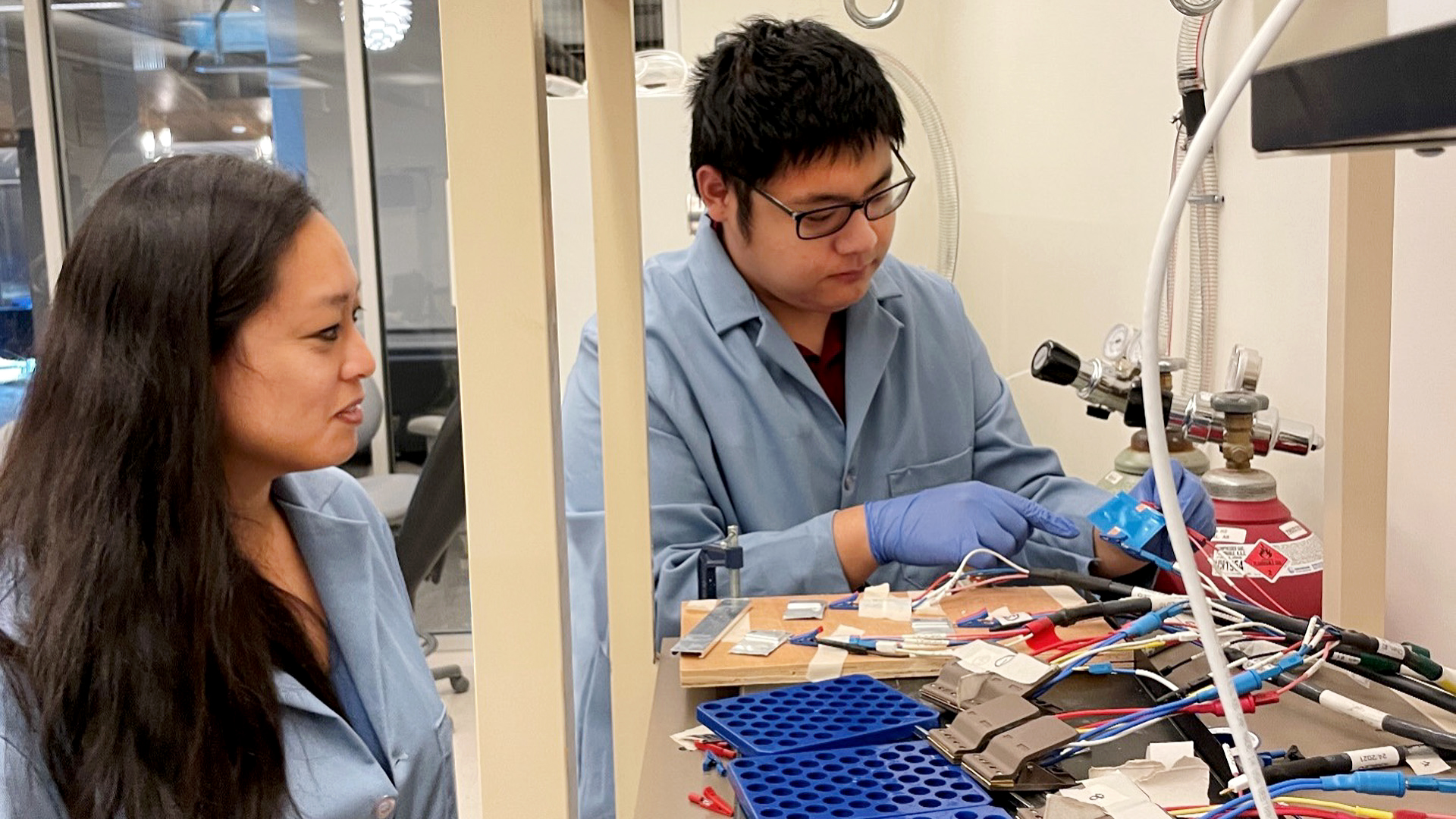 Candace Chan, left, an associate professor of materials science and engineering in the Ira A. Fulton Schools of Engineering at Arizona State University, observes materials science and engineering doctoral student Jinzhao Guo, right, as he connects a solid-state battery to testing equipment. 
