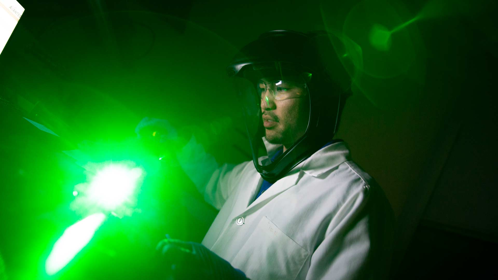 graduate student working in lab with green light