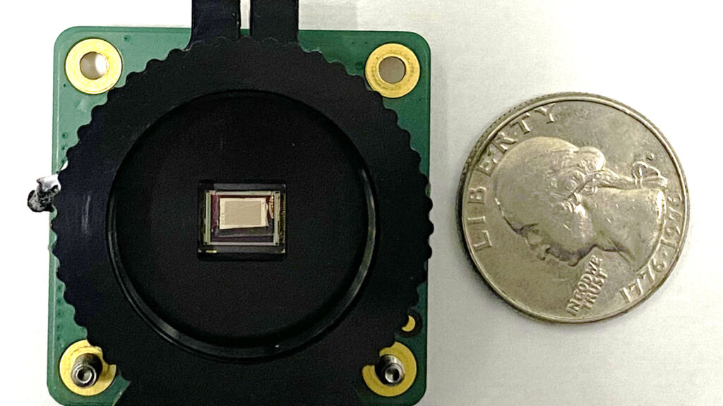 a chip-integrated polarimetric imaging sensor next to a quarter 