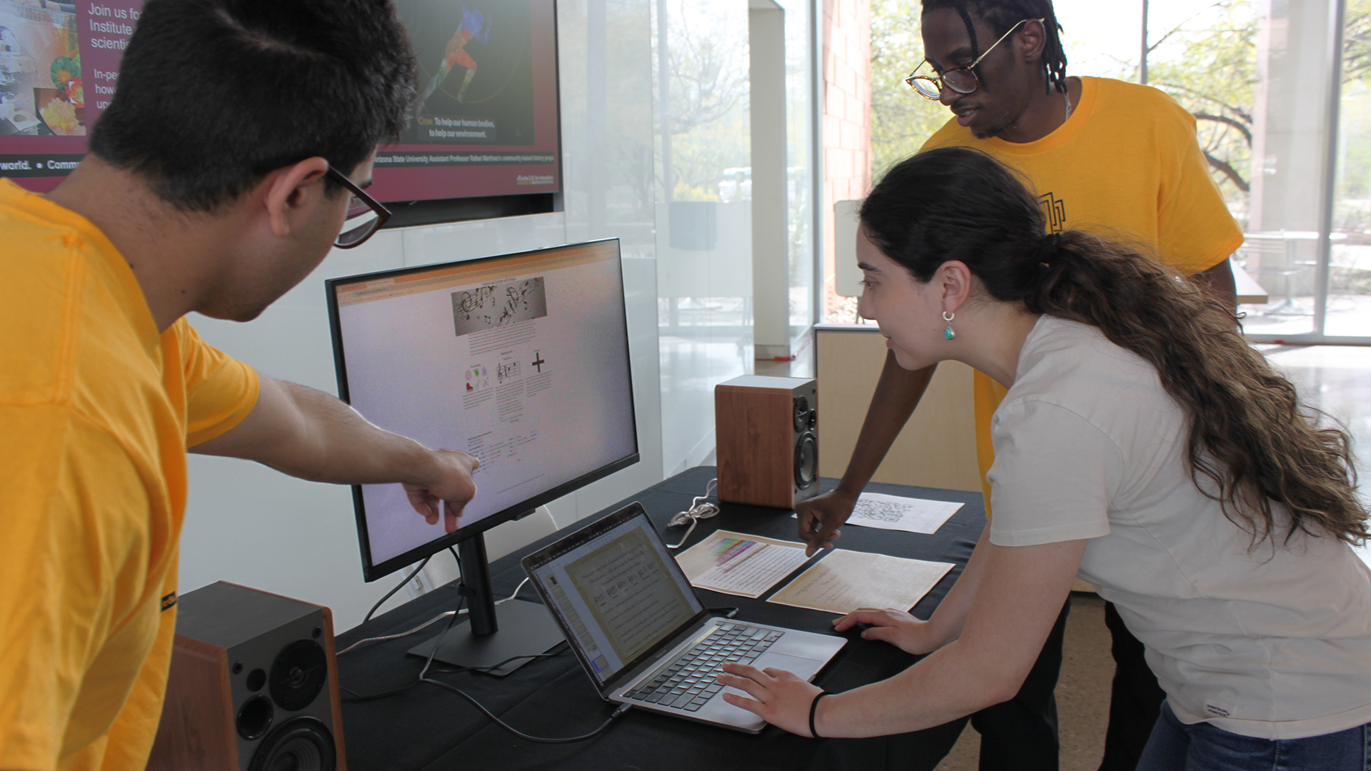 Student volunteers demonstrate software that captures cancer as music at ASU Open Door event.