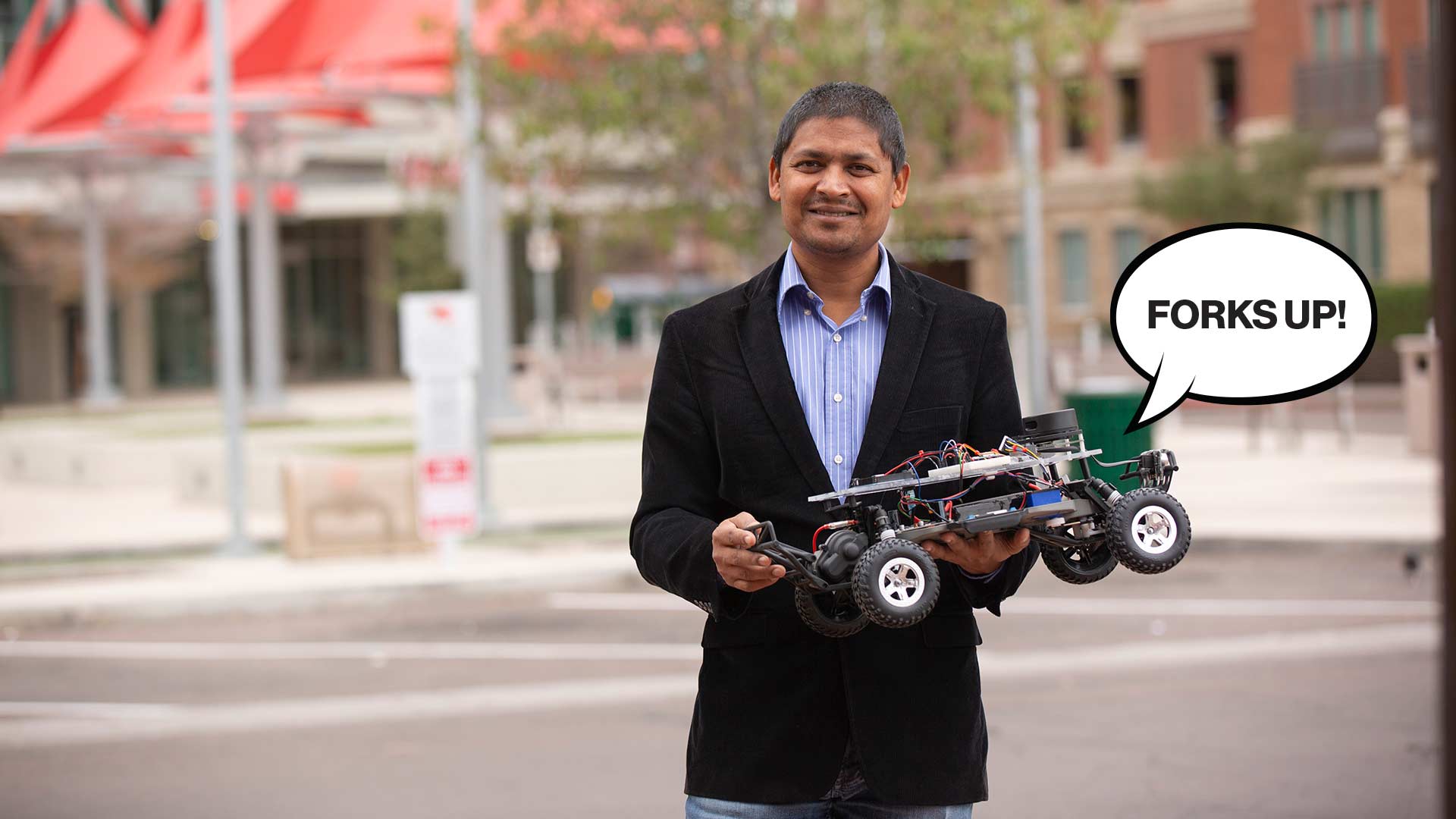 Aviral Shrivastava holding a small vehicle with a speech bubble that says "Forks up!"