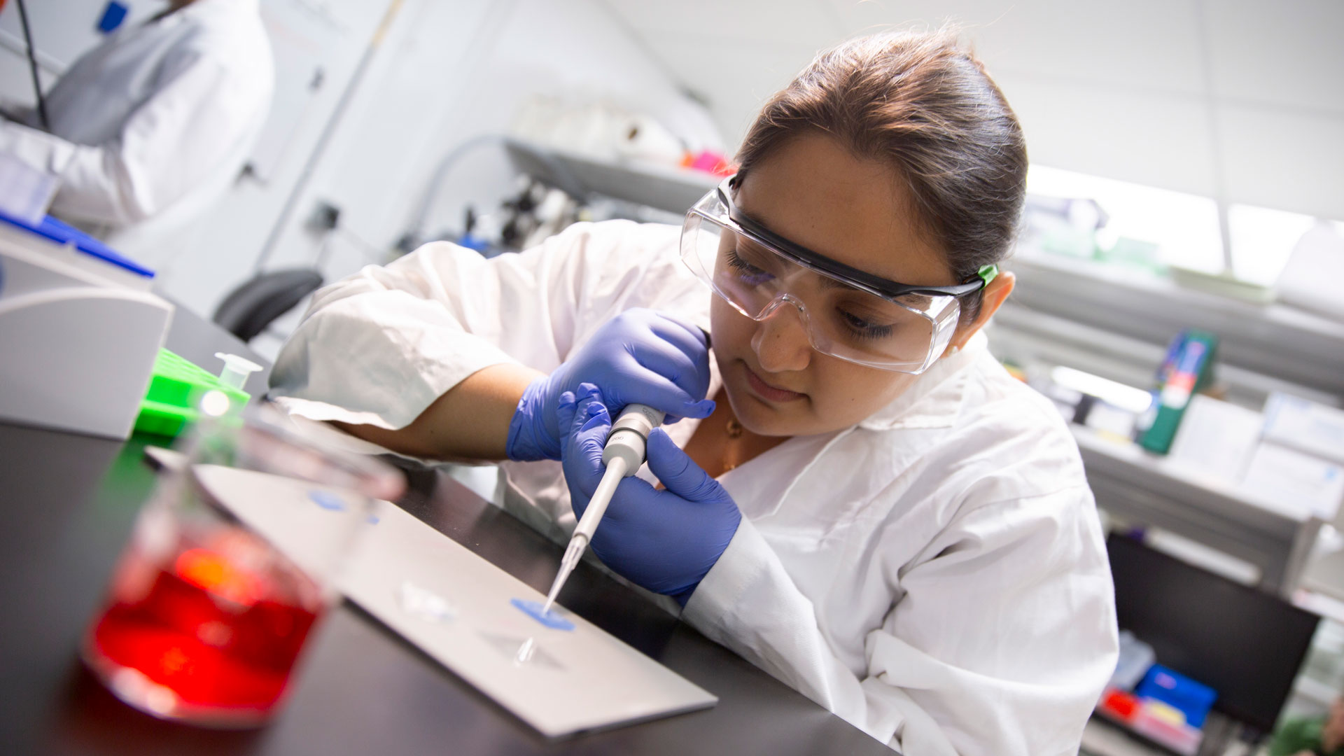 FURI student researcher Emily Mahadevan works with a pipette in the lab.