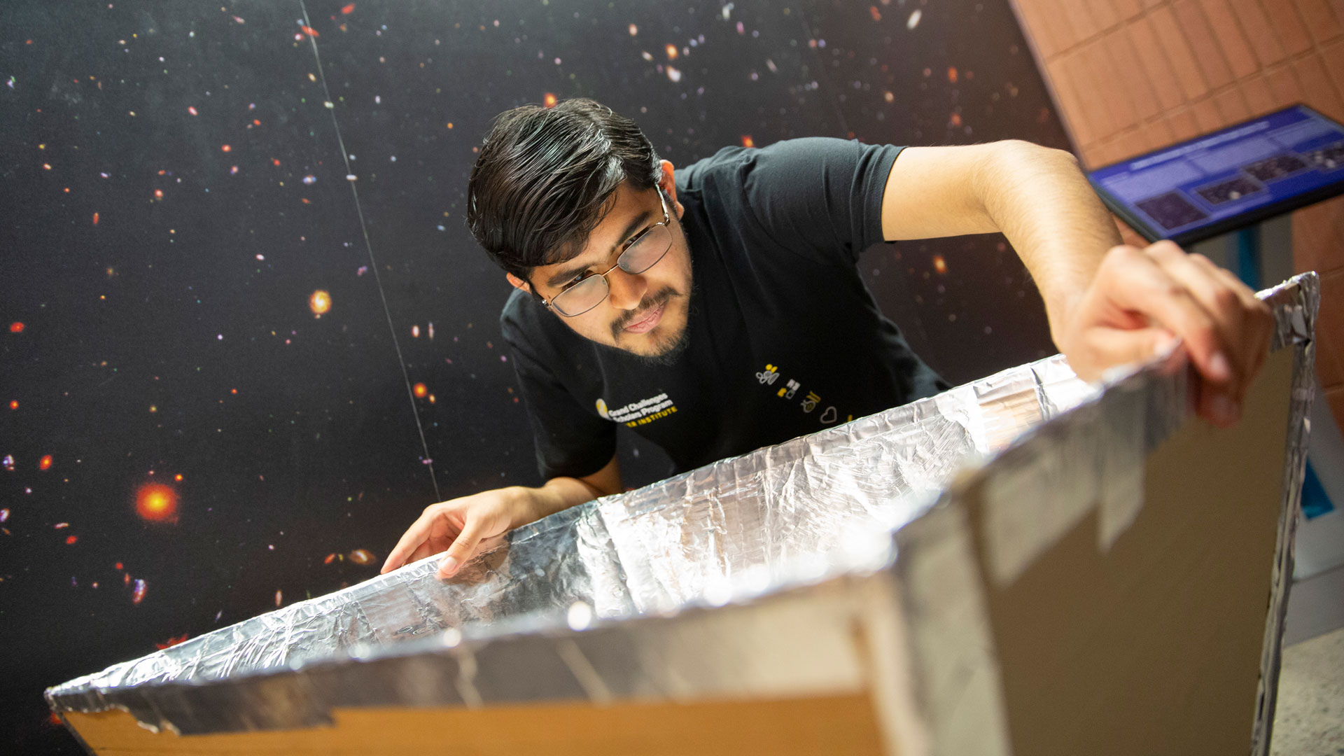 Ritwik Sharma works with a foil covered structure used to help teach astronomy to K-12 students as part of a Grand Challenges Scholars Program research stipend project.