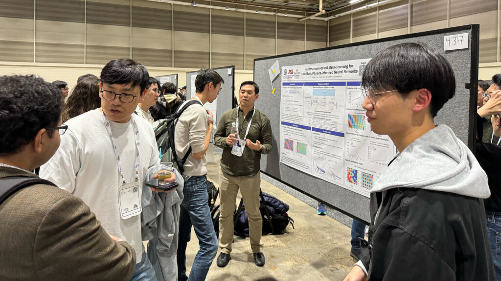 Kookjin Lee discusses a poster with a group of students