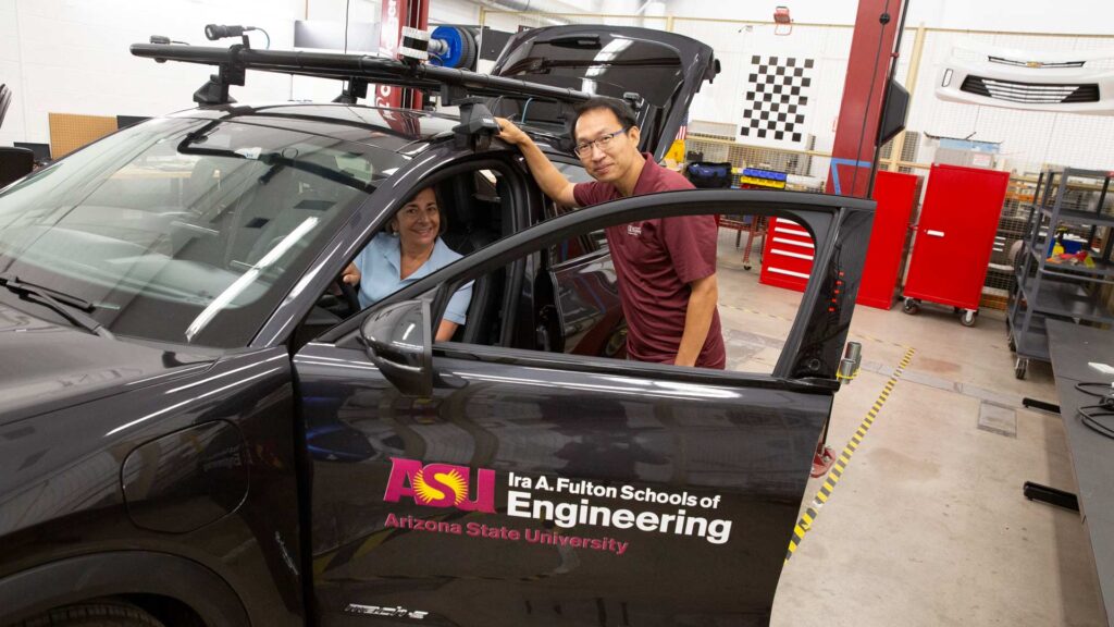 Norma Faris Hubele examines an automobile used by researchers in the Battery Electric & Intelligent Vehicle Lab