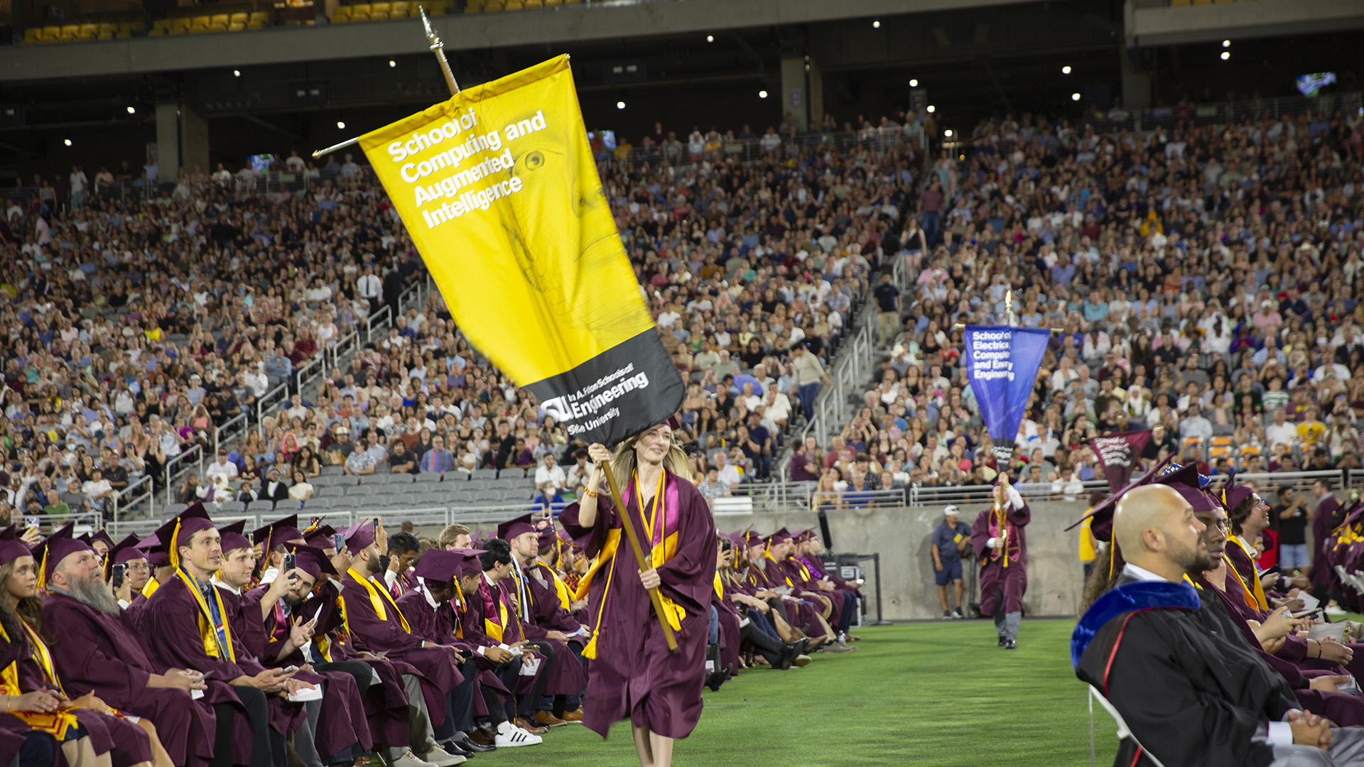 Emily Williamson carries the gonfalon at convocation