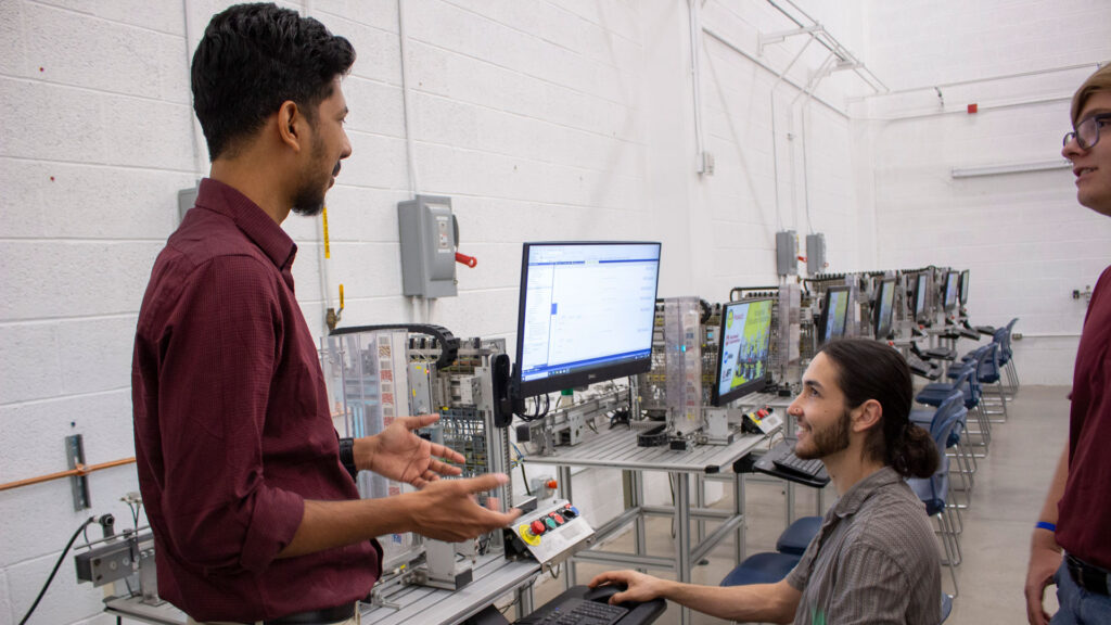 Rahul Pushparajan talks to students in the Industrial Automation and Robotic Systems Laboratory. 