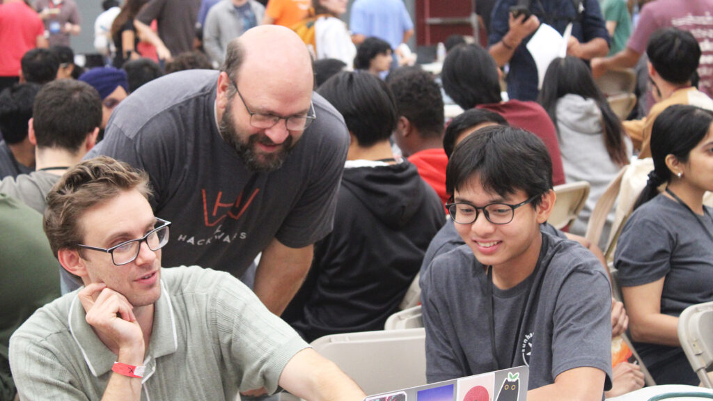 Three students collaborate on a project during the sunhacks hackathon at ASU.